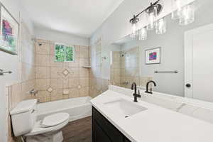Bathroom featuring  shower combination, vanity, and dark wood-style floors