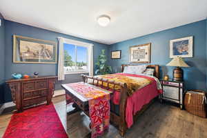 Bedroom with wood finished floors and baseboard heating