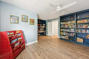 Sitting room with wood finished floors and a ceiling fan