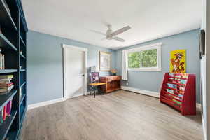 Office area with a baseboard radiator, light wood-type flooring, and a ceiling fan