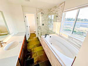 Bathroom with vanity, a marble finish shower, and a bath