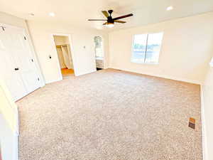 Unfurnished bedroom with recessed lighting, light colored carpet, a walk in closet, and ceiling fan