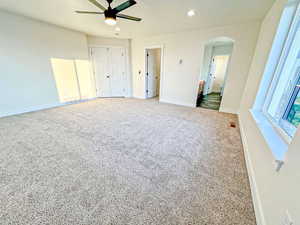Unfurnished bedroom with recessed lighting, carpet floors, arched walkways, a closet, and ceiling fan