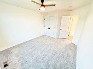 Unfurnished bedroom featuring carpet floors, ceiling fan, and a closet