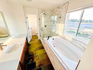 Full bathroom featuring vanity, a marble finish shower, and a garden tub