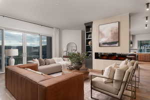 Living area featuring light wood-type flooring, recessed lighting, and built in shelves