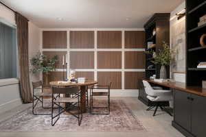 Home office with light carpet and built in study area