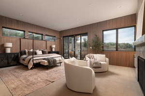 Bedroom featuring wooden walls, a fireplace, access to outside, recessed lighting, and carpet floors