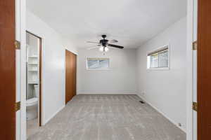 Unfurnished bedroom with light colored carpet and a ceiling fan