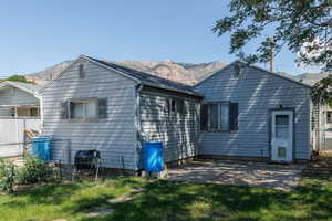 Back of house with a mountain view and a patio