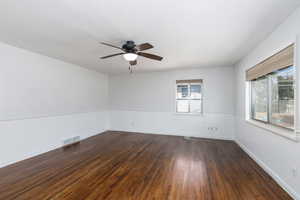 Spare room featuring dark wood-style floors and ceiling fan
