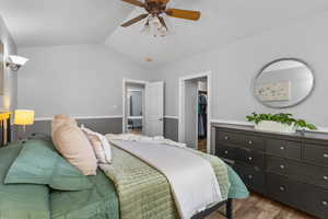 Bedroom with lofted ceiling, wood finished floors, a spacious closet, and ceiling fan