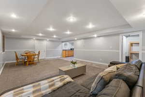 Walk out basement apartment with a kitchenette. Living area with carpet flooring, a raised ceiling, and recessed lighting