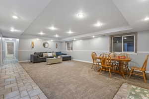 Walk out basement with seperate entrance. Living room with light carpet, a tray ceiling, light stone finish floors, and recessed lighting