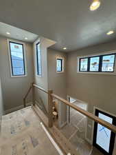Stairway featuring recessed lighting and a textured ceiling