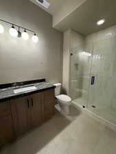 Bathroom featuring vanity, a shower stall, recessed lighting, and light tile patterned floors