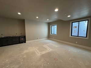 Unfurnished room with recessed lighting, beverage cooler, and a textured ceiling
