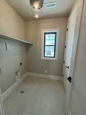 Laundry room with a textured ceiling and electric dryer hookup