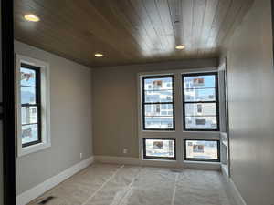 Unfurnished room featuring wood ceiling and healthy amount of natural light