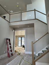 Stairs with recessed lighting and a high ceiling