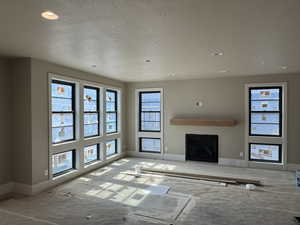Unfurnished living room with a fireplace and a textured ceiling