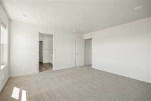 Unfurnished bedroom with light carpet and ensuite bath
