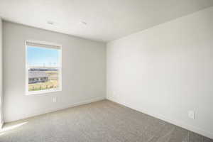 Empty room featuring carpet flooring and a textured ceiling