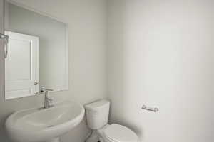 Half bathroom featuring toilet and a sink