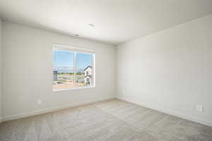 Carpeted empty room featuring baseboards and a textured ceiling