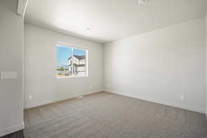 Unfurnished room with light colored carpet and a textured ceiling