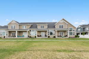 Traditional-style house with covered porch, a front yard, french doors, and a shingled roof