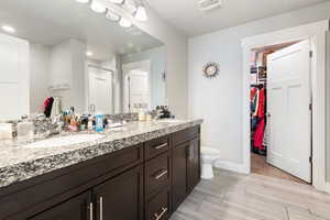 Bathroom featuring a walk in closet, double vanity, and a shower stall