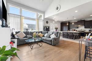 Living room featuring light wood-style flooring, recessed lighting, and lofted ceiling