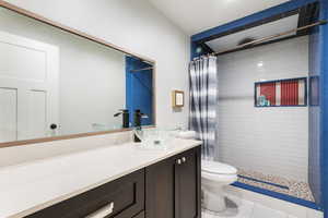 Bathroom featuring a stall shower, vanity, and light tile patterned flooring