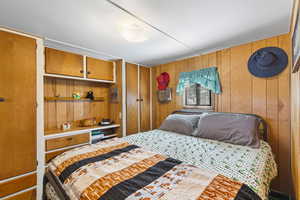 Bedroom featuring wood walls