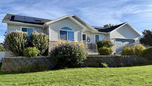 Ranch-style home featuring solar panels and a front lawn