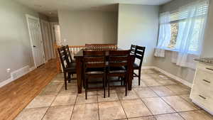 Dining area featuring light tile patterned floors and baseboards