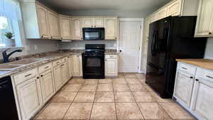 Kitchen featuring black appliances and light tile patterned floors