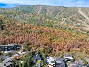 Aerial view of property and surrounding area featuring nearby suburban area and mountains