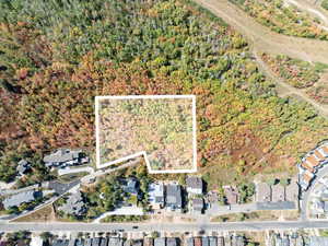 Aerial view of property and surrounding area with property boundaries highlighted and nearby suburban area