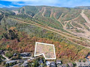 Aerial overview of property's location with property boundaries highlighted and a mountain backdrop
