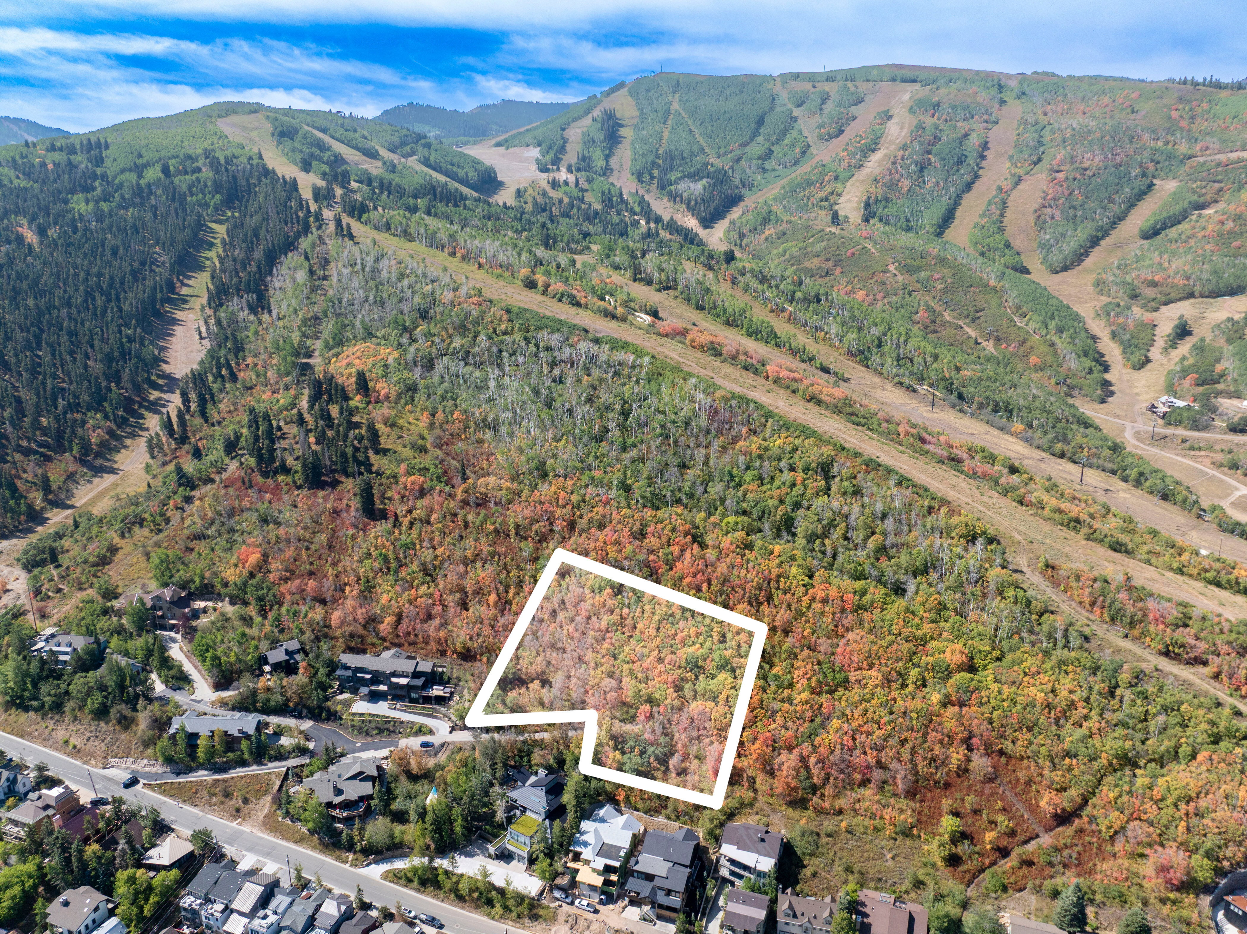 Aerial view of property and surrounding area featuring property boundaries highlighted and nearby suburban area