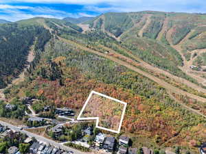 Aerial view of property and surrounding area featuring property boundaries highlighted and nearby suburban area