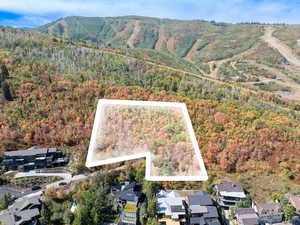 Aerial view of property and surrounding area featuring property parcel outlined and mountains
