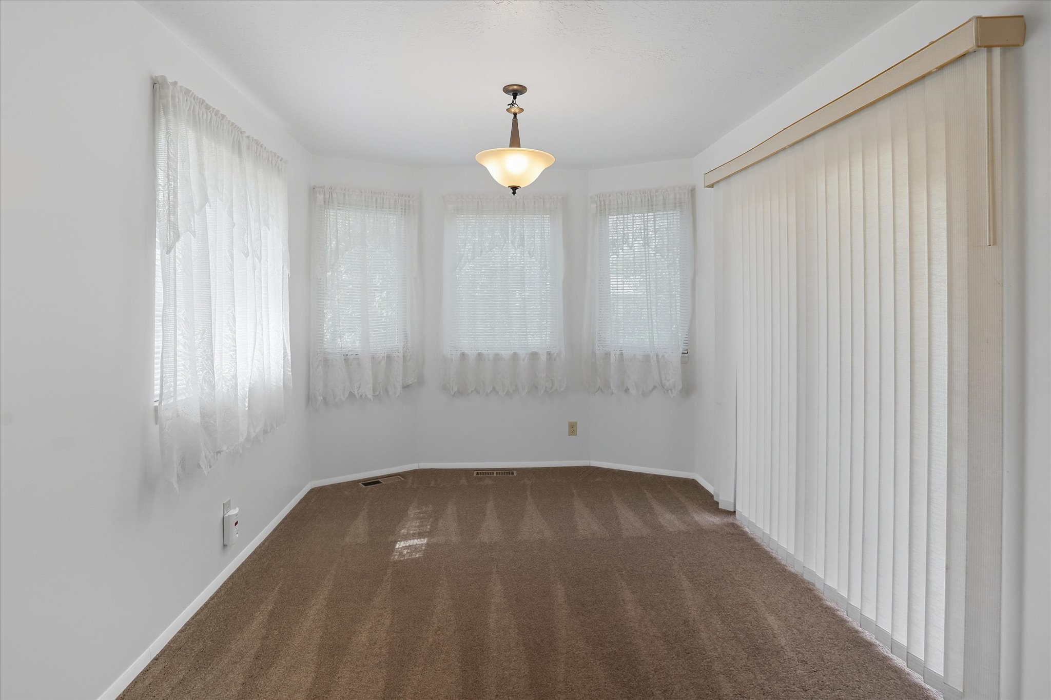Dining area with dark carpet and white baseboards