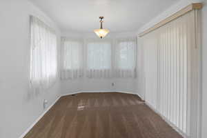 Dining area with dark carpet and white baseboards