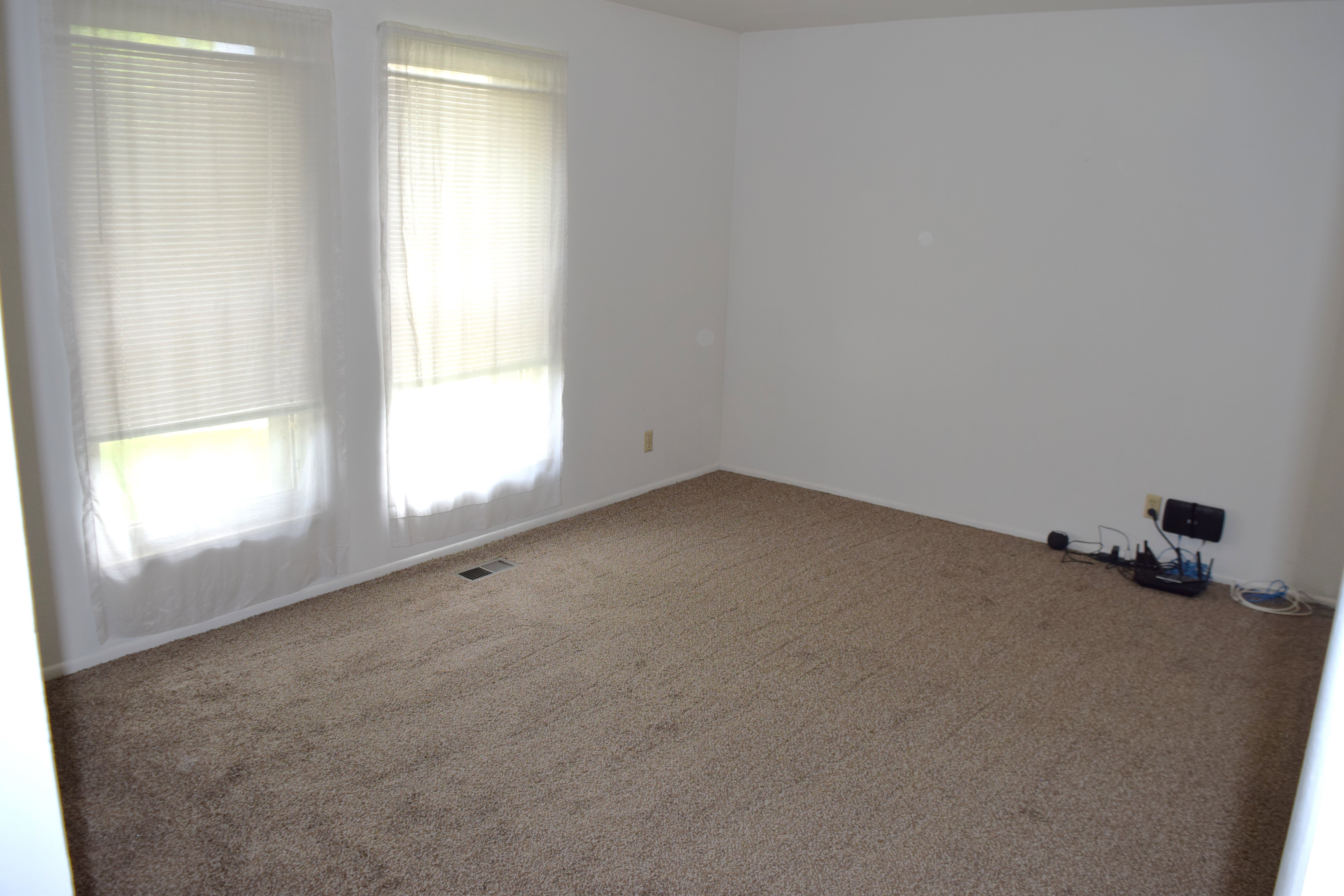 Empty room featuring carpet flooring and baseboards