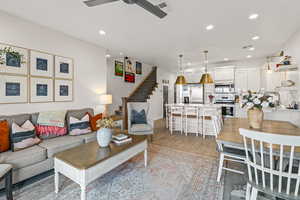 Living room featuring stairs, light wood-style floors, and recessed lighting