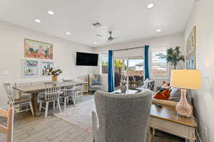 Living room with a ceiling fan, recessed lighting, and light tile flooring