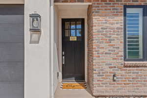 View of exterior entry with brick siding